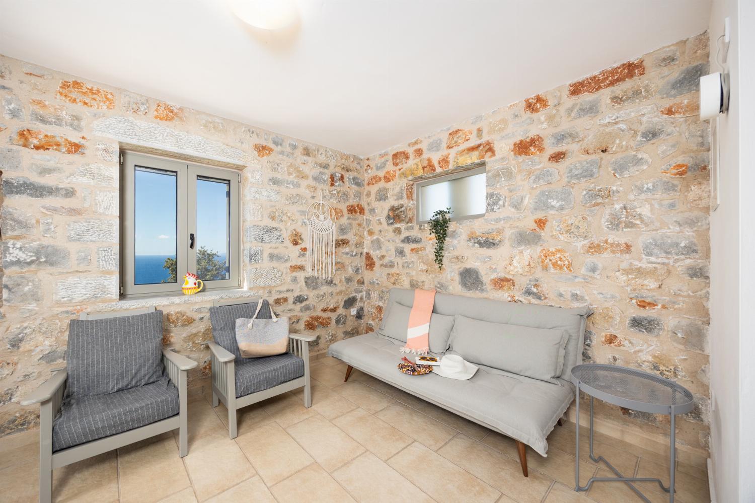 Open-plan living room with sofa, dining area, kitchen, A/C, WiFi internet, and satellite TV