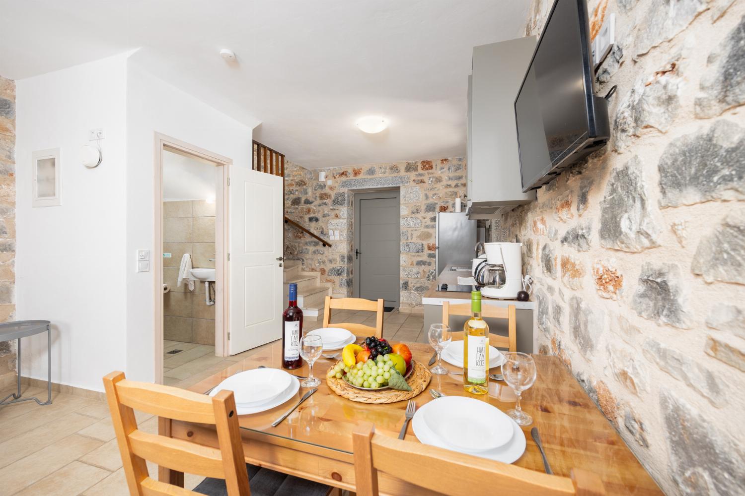 Open-plan living room with sofa, dining area, kitchen, A/C, WiFi internet, and satellite TV