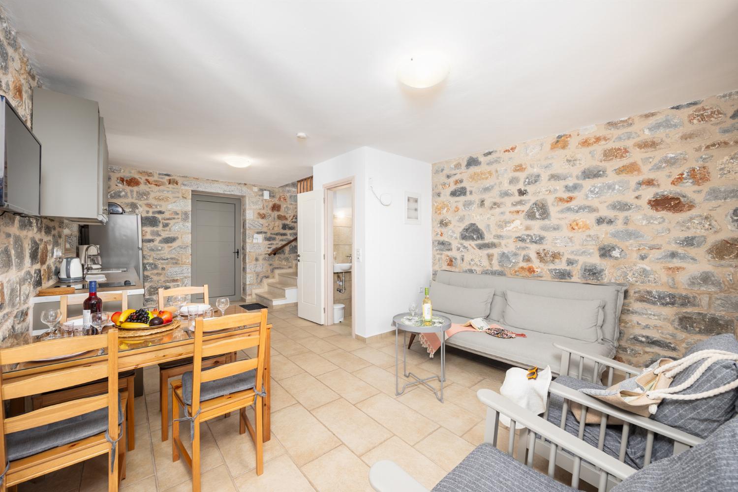 Open-plan living room with sofa, dining area, kitchen, A/C, WiFi internet, and satellite TV