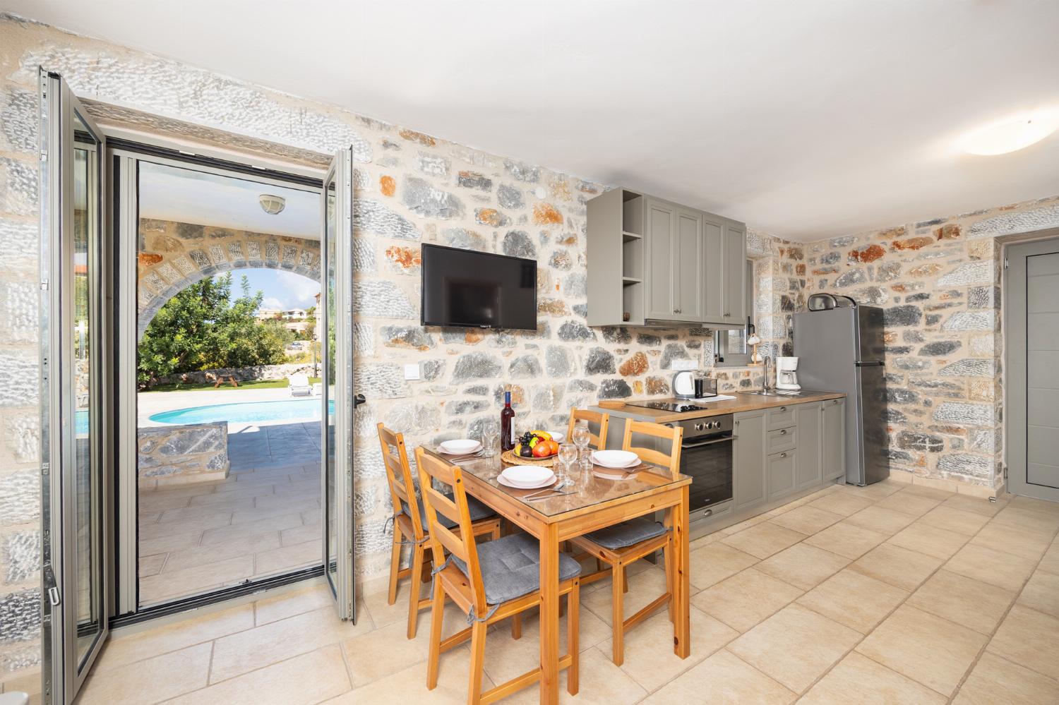 Open-plan living room with sofa, dining area, kitchen, A/C, WiFi internet, and satellite TV