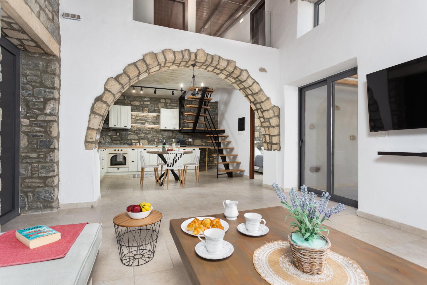 Open-plan living room with sofa, dining area, kitchen, A/C, WiFi internet, and satellite TV