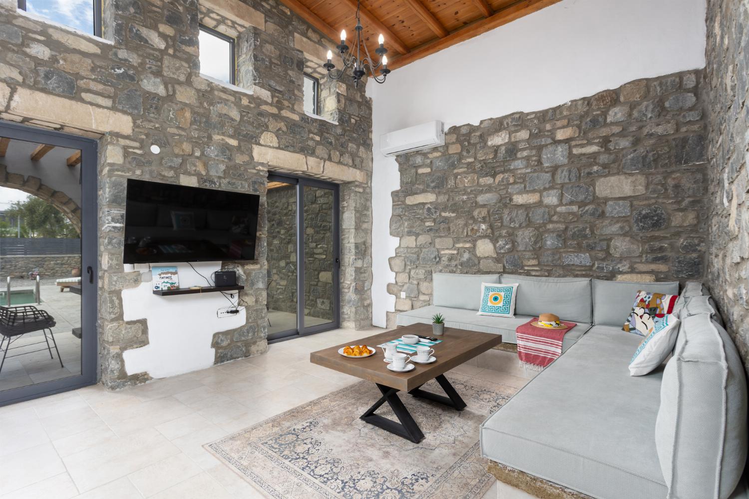 Open-plan living room with sofa, dining area, kitchen, A/C, WiFi internet, and satellite TV
