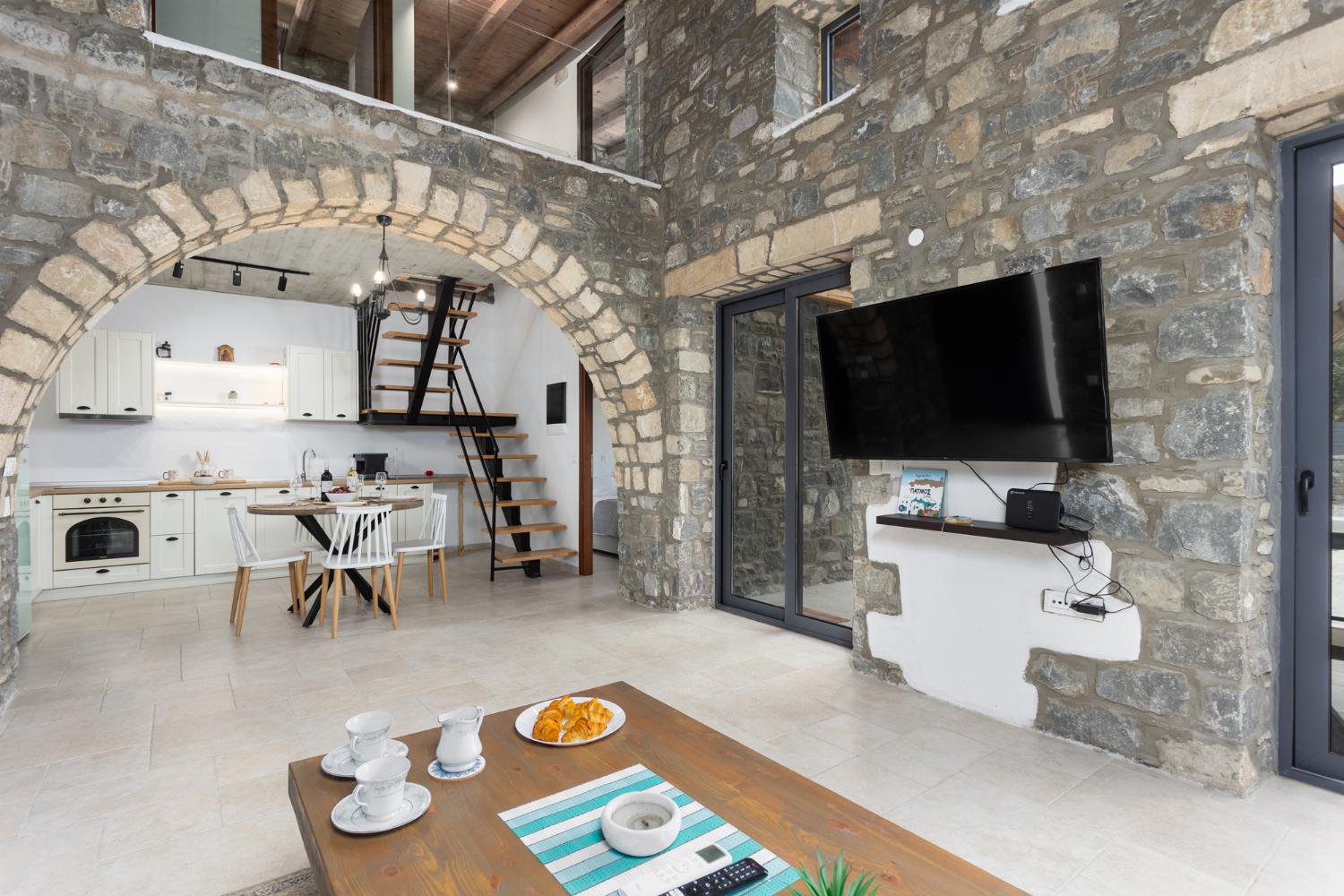 Open-plan living room with sofa, dining area, kitchen, A/C, WiFi internet, and satellite TV