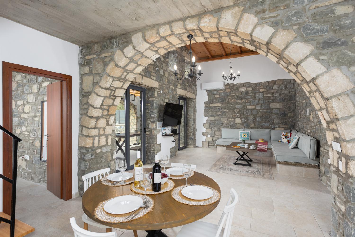 Open-plan living room with sofa, dining area, kitchen, A/C, WiFi internet, and satellite TV