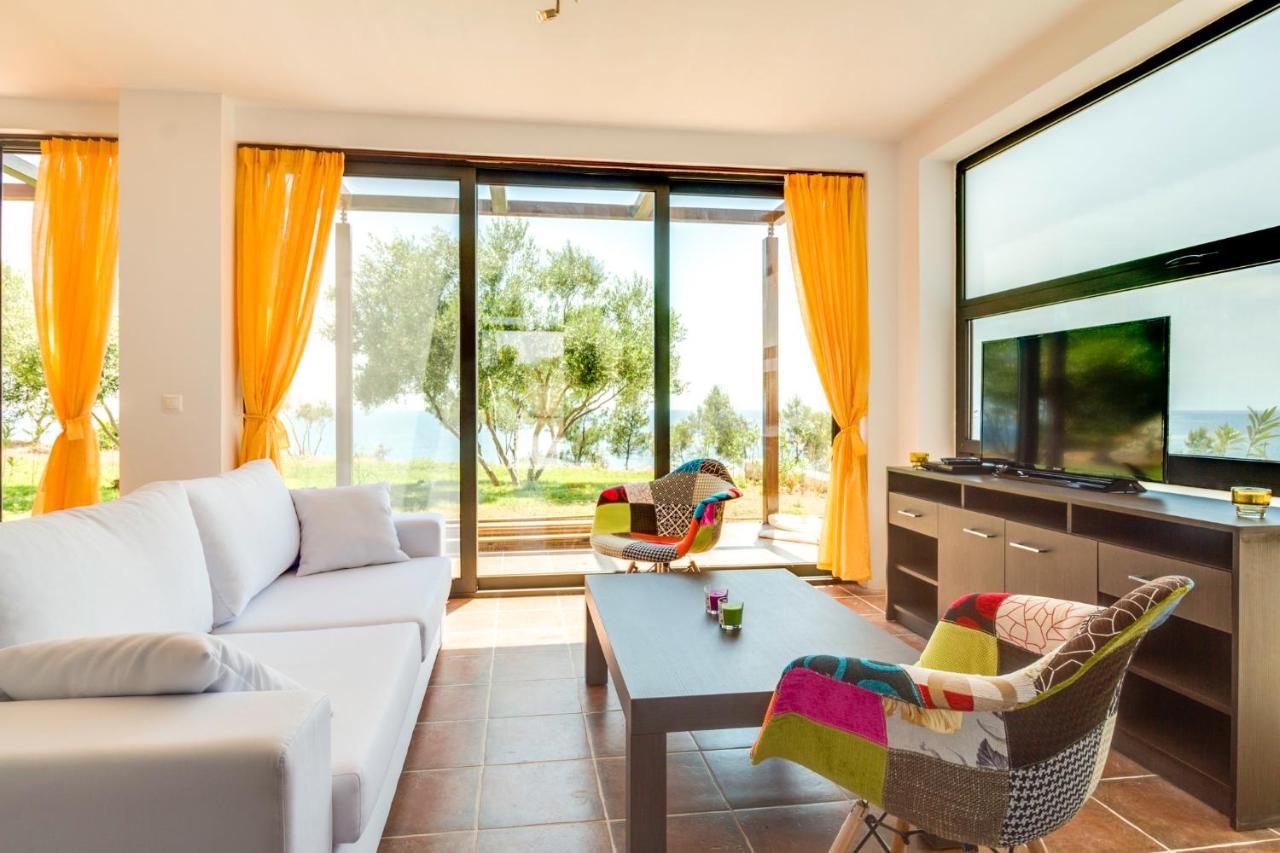 Open-plan living room with sofas, dining area with panoramic sea view