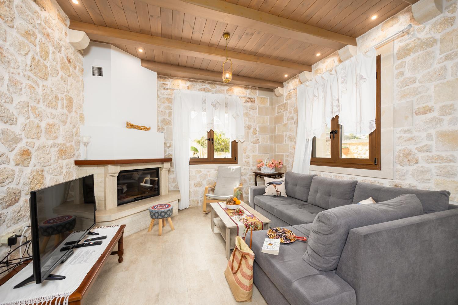 Living room with sofa, dining area, ornamental fireplace, A/C, WiFi internet, and satellite TV