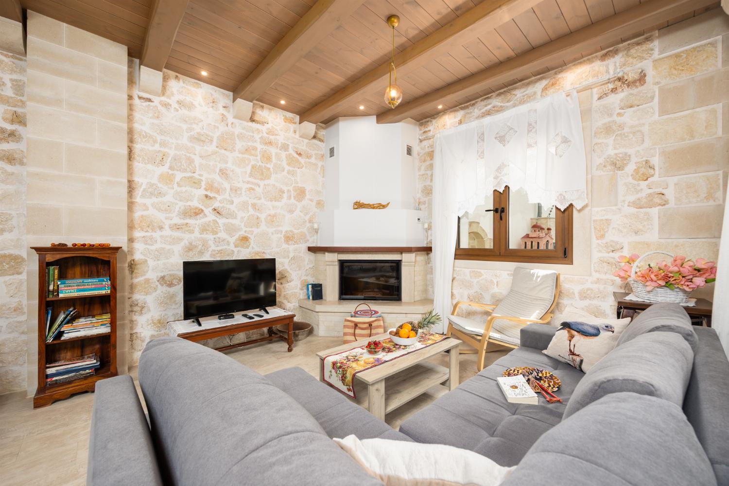 Living room with sofa, dining area, ornamental fireplace, A/C, WiFi internet, and satellite TV