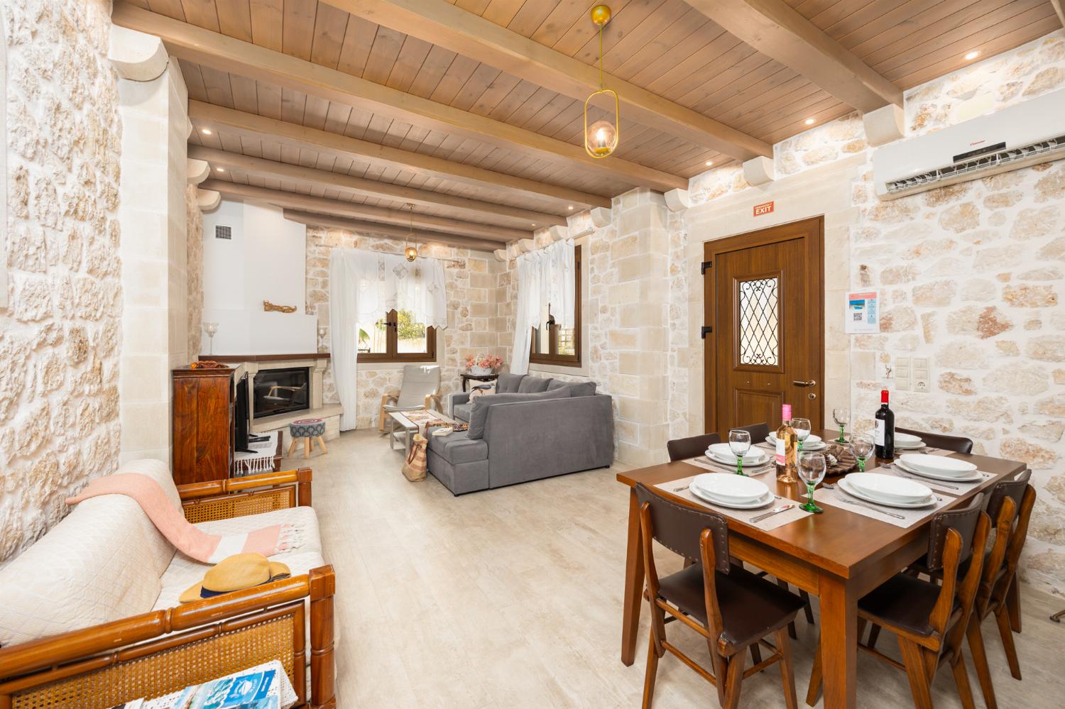 Living room with sofa, dining area, ornamental fireplace, A/C, WiFi internet, and satellite TV