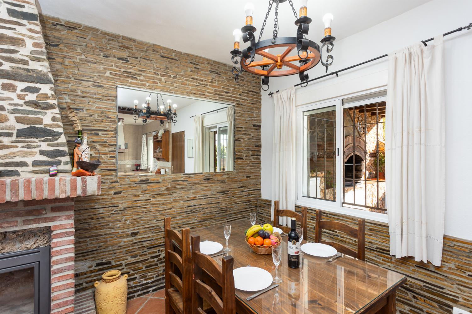 Open-plan living room with sofa, dining area, kitchen, ornamental fireplace, A/C, WiFi internet, and satellite TV