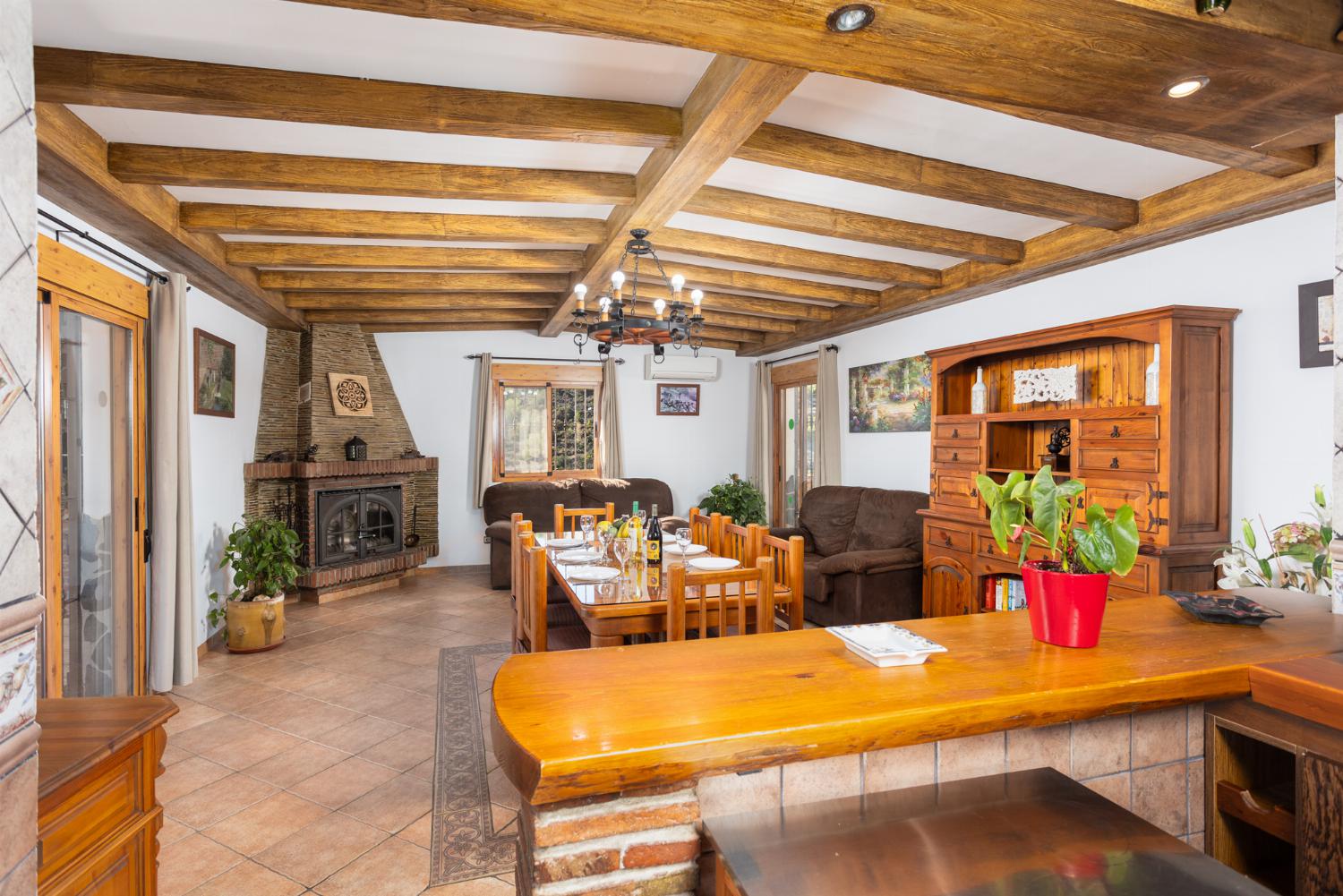 Open-plan living room with sofas, dining area, kitchen, ornamental fireplace, A/C, WiFi internet, and satellite TV