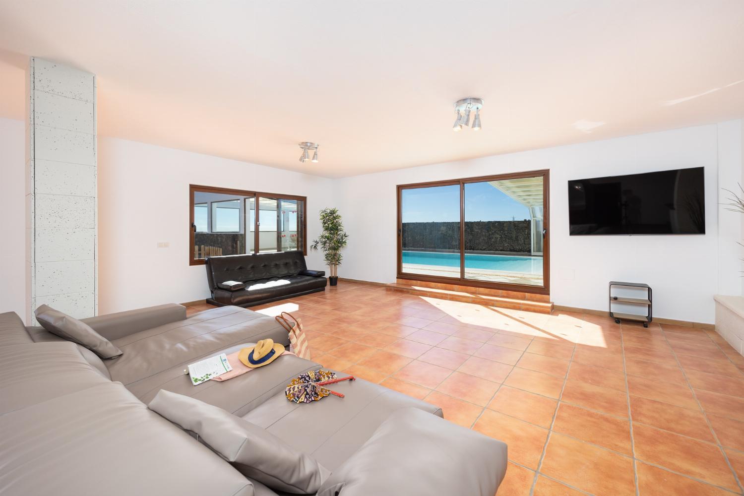 Living area with sofa, dining area, kitchenette, satellite TV, and sea views