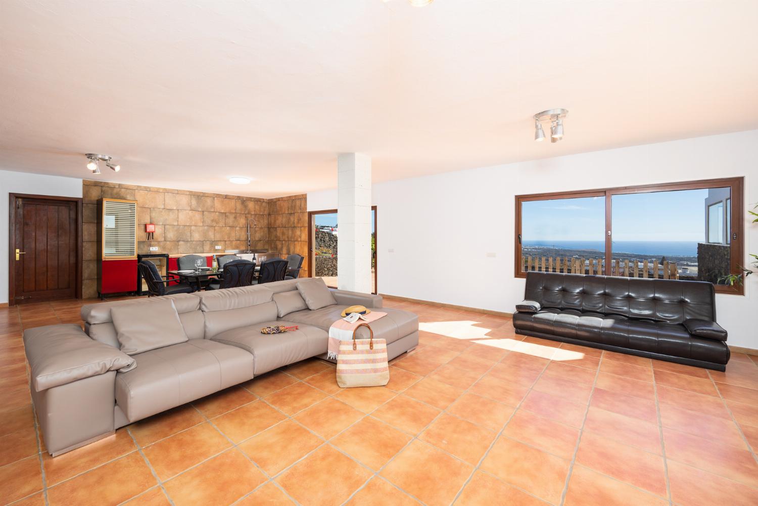 Living area with sofa, dining area, kitchenette, satellite TV, and sea views
