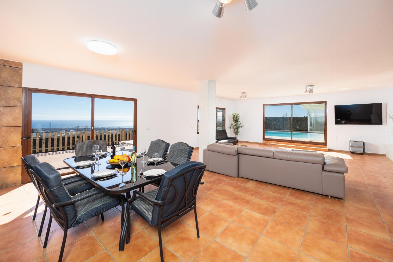 Living area with sofa, dining area, kitchenette, satellite TV, and sea views