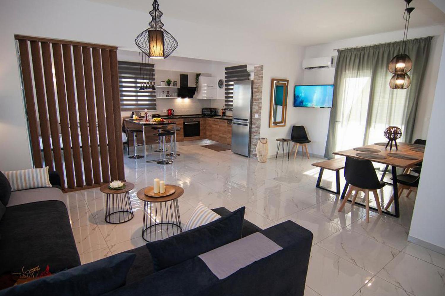 Open-plan living room with sofas, dining areas and kitchen