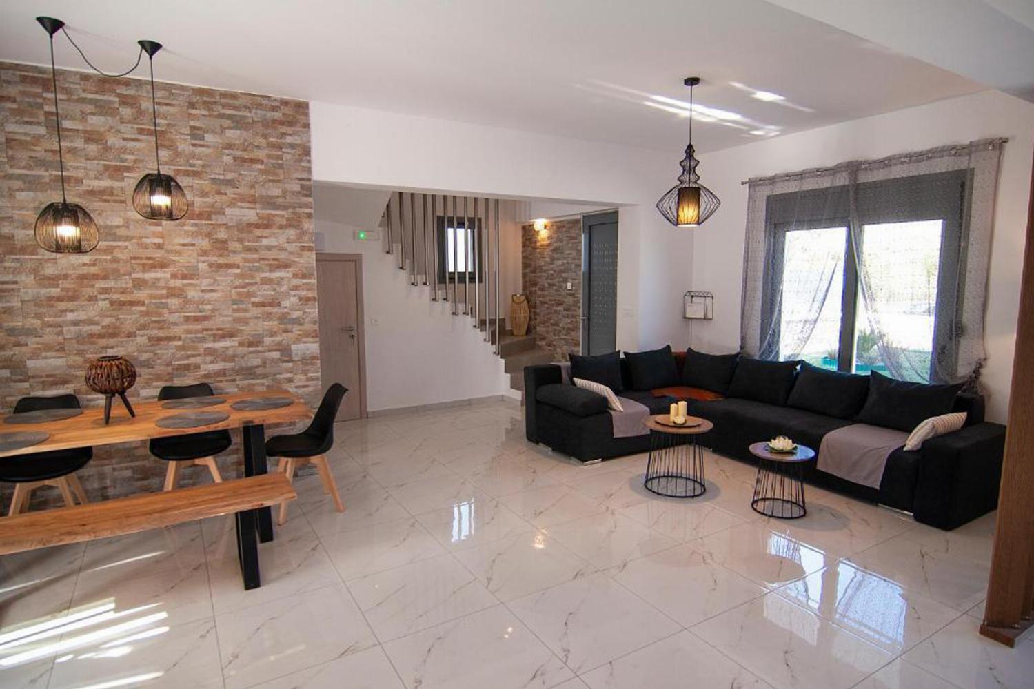 Open-plan living room with sofas, dining areas and stairway