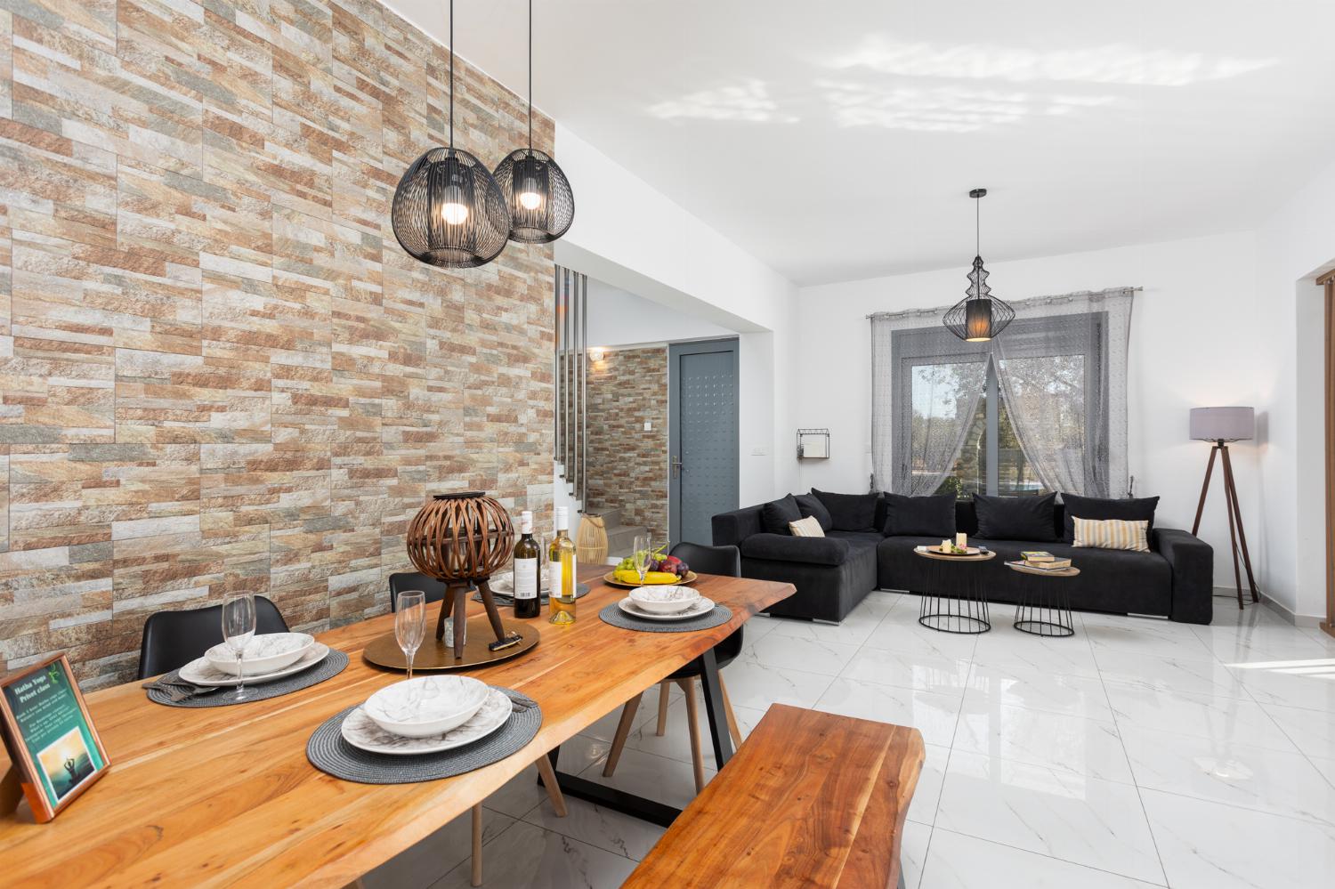 Open-plan living room with sofa, dining area, kitchen, A/C, WiFi internet, and satellite TV