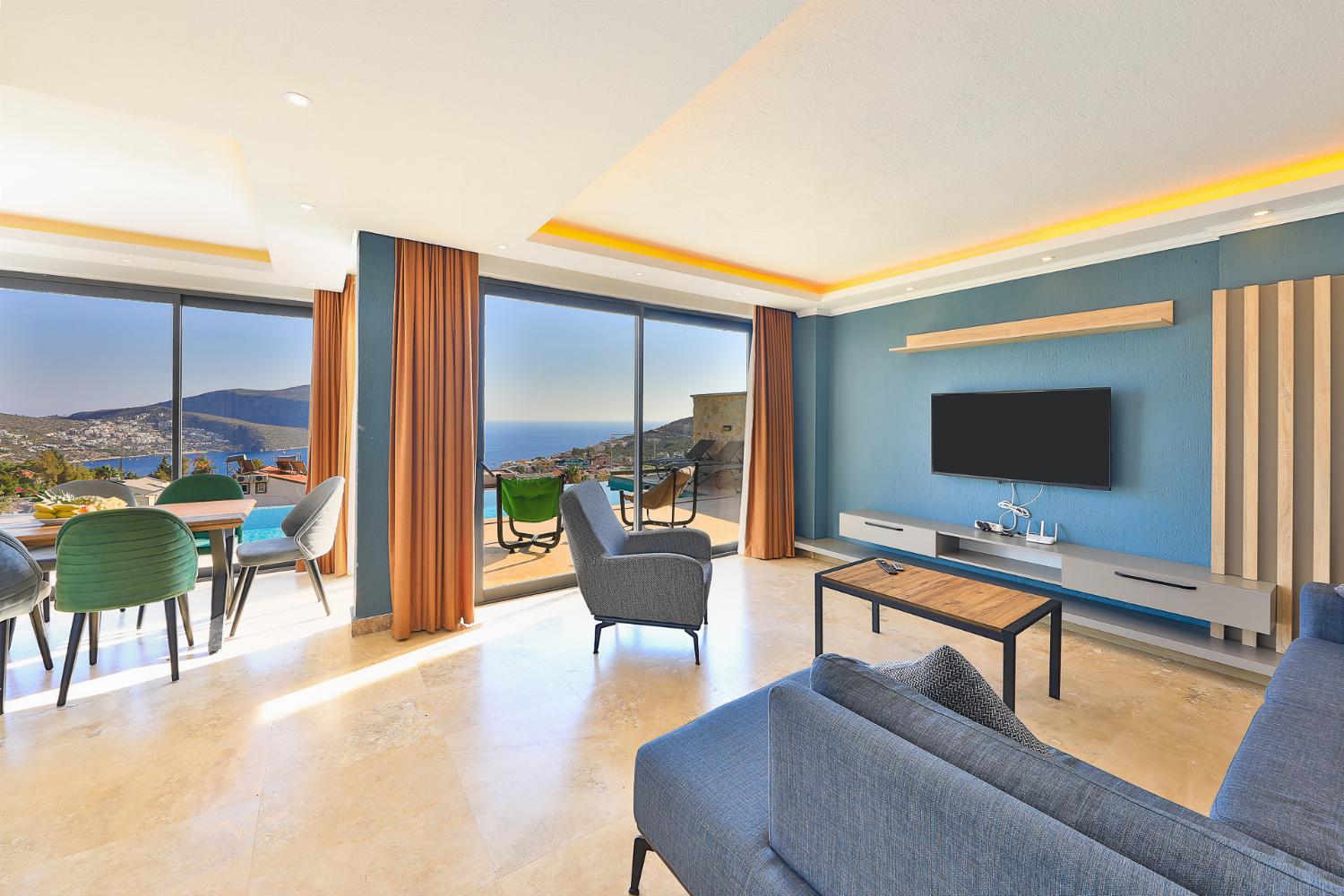 Open-plan living room with sofas, dining areas, WiFi internet, satellite TV, and terrace access with panoramic sea views