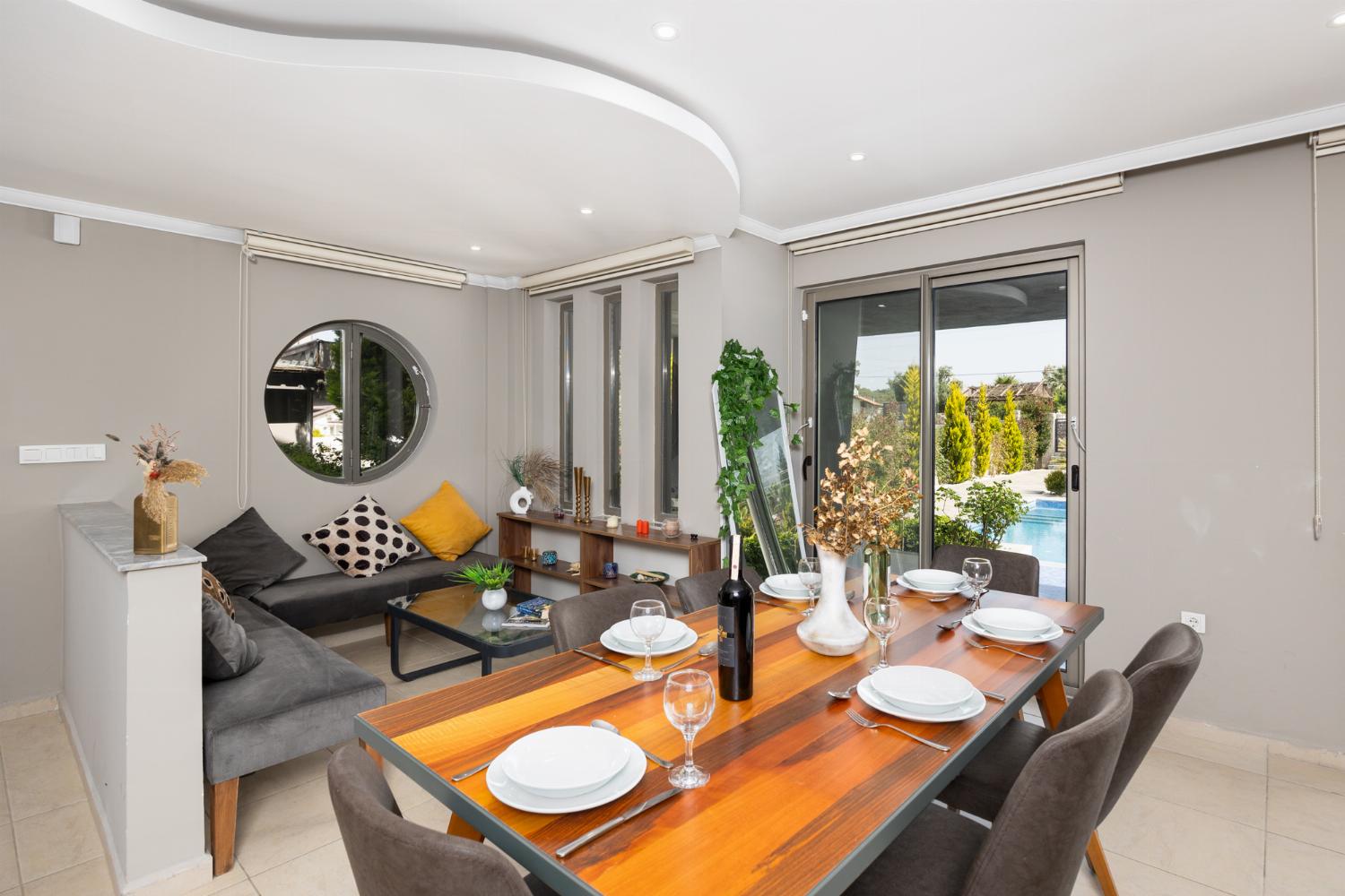 Open-plan living room with sofas, dining area, kitchen, A/C, WiFi internet, and satellite TV