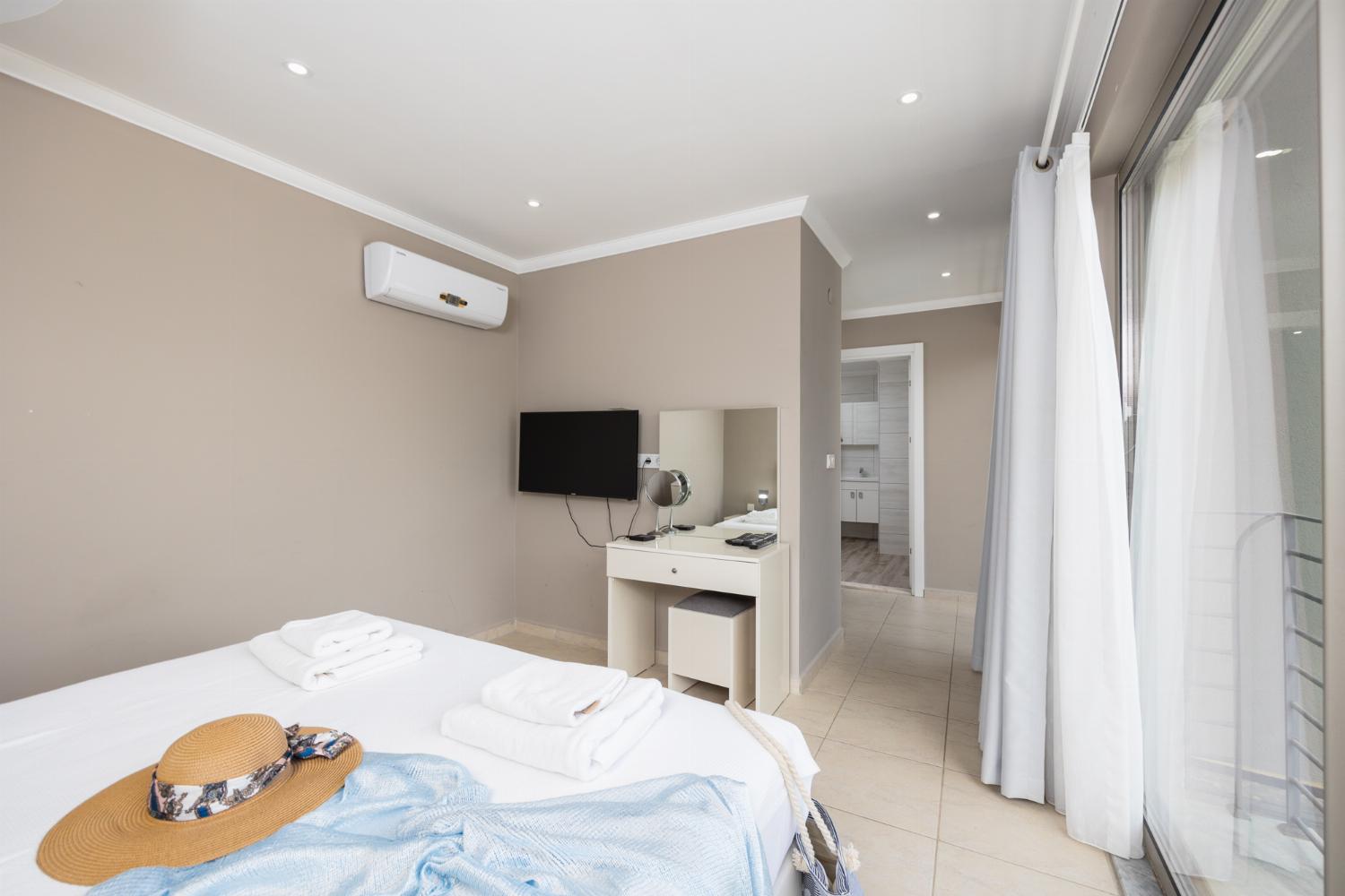 Double bedroom with en suite bathroom, A/C, and TV