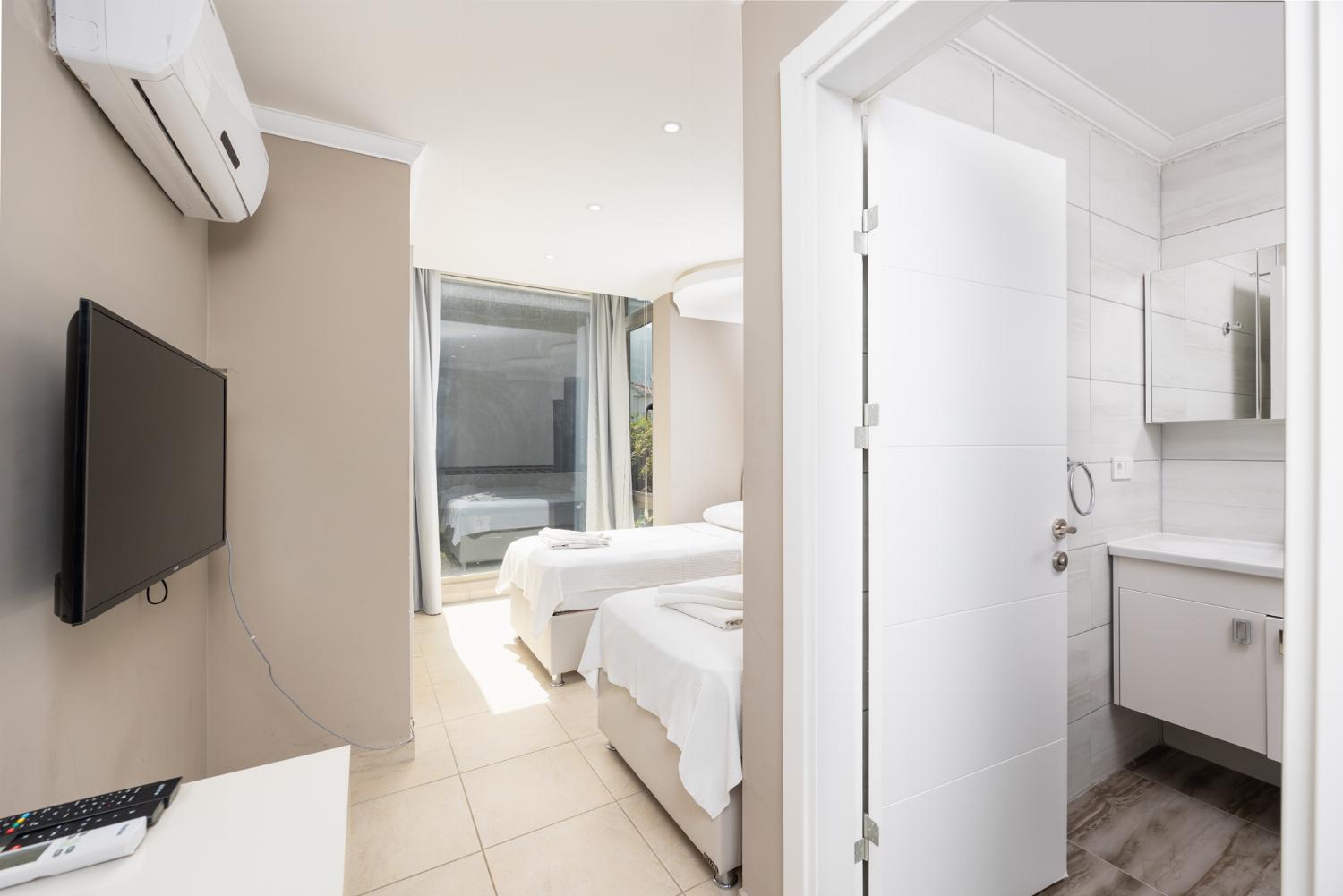 Twin bedroom with en suite bathroom, A/C, and TV
