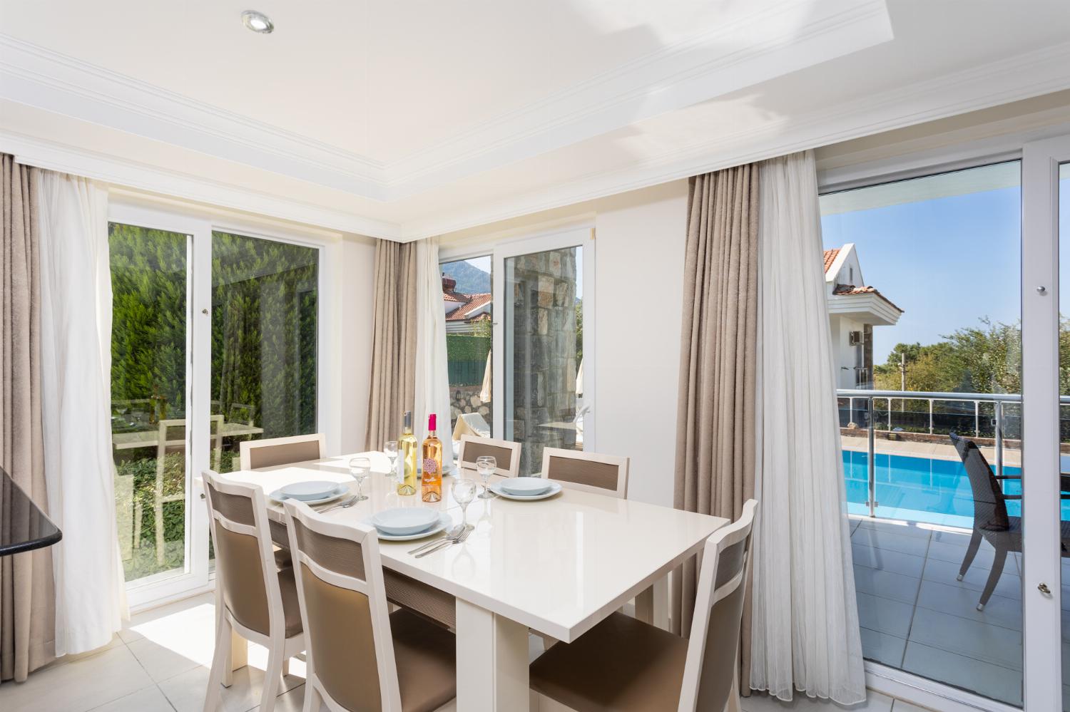 Open-plan living room with sofas, dining area, kitchen, ornamental fireplace, A/C, WiFi internet, and satellite TV