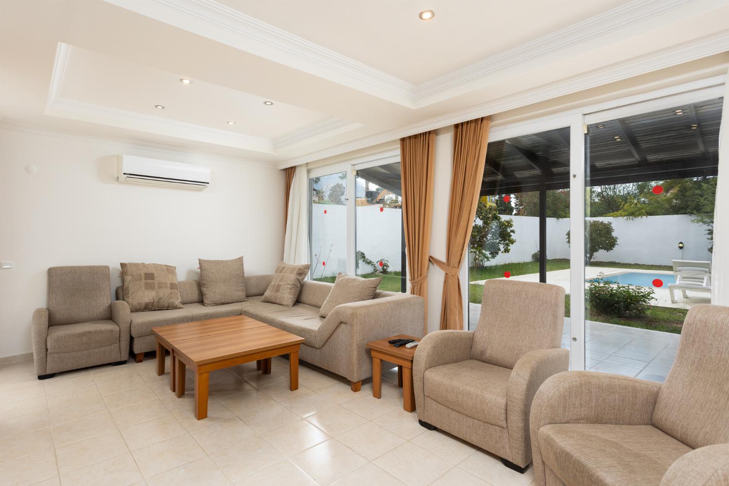 Open-plan living room with sofas, dining area, kitchen, A/C, WiFi internet, and satellite TV