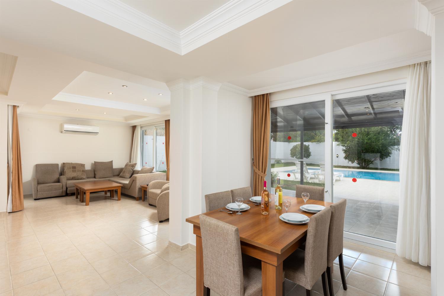 Open-plan living room with sofas, dining area, kitchen, A/C, WiFi internet, and satellite TV