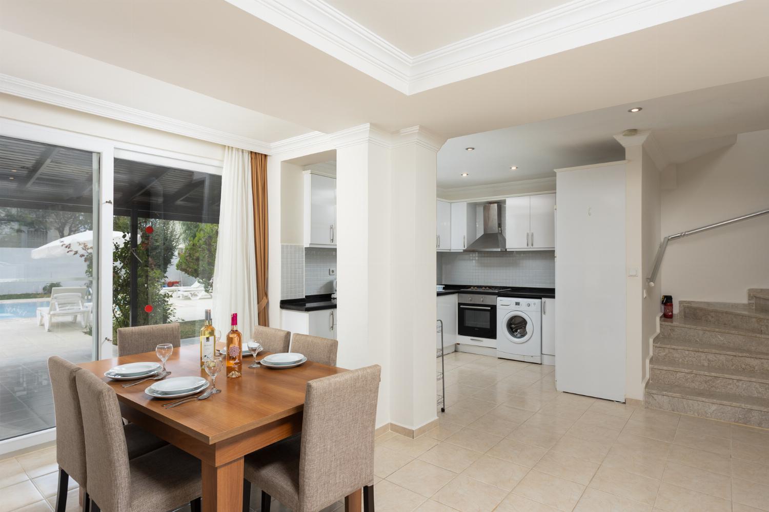 Open-plan living room with equipped kitchen, dining area and terrace access