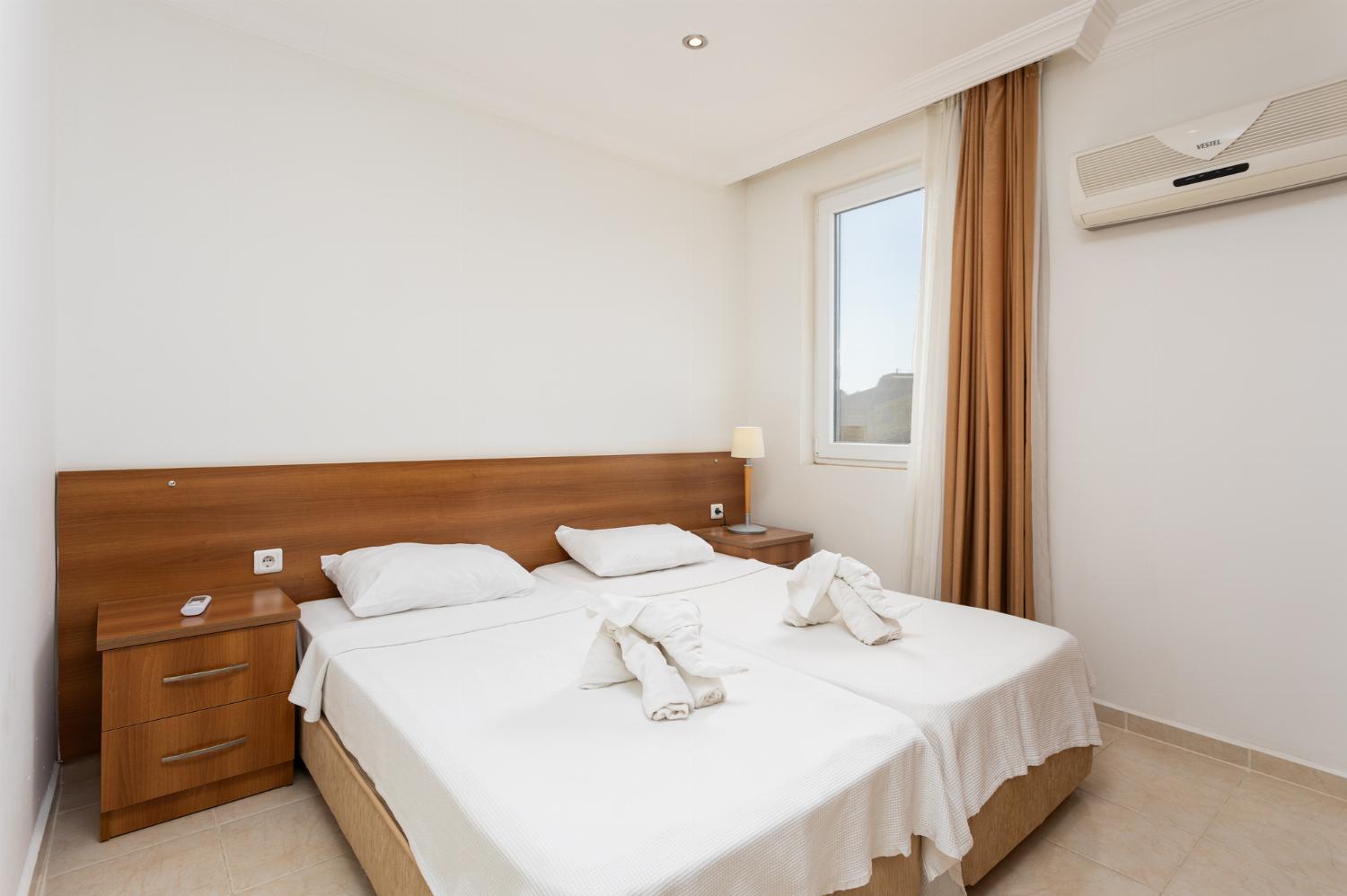 Bedroom with twin beds and single bed, en suite bathroom, and A/C