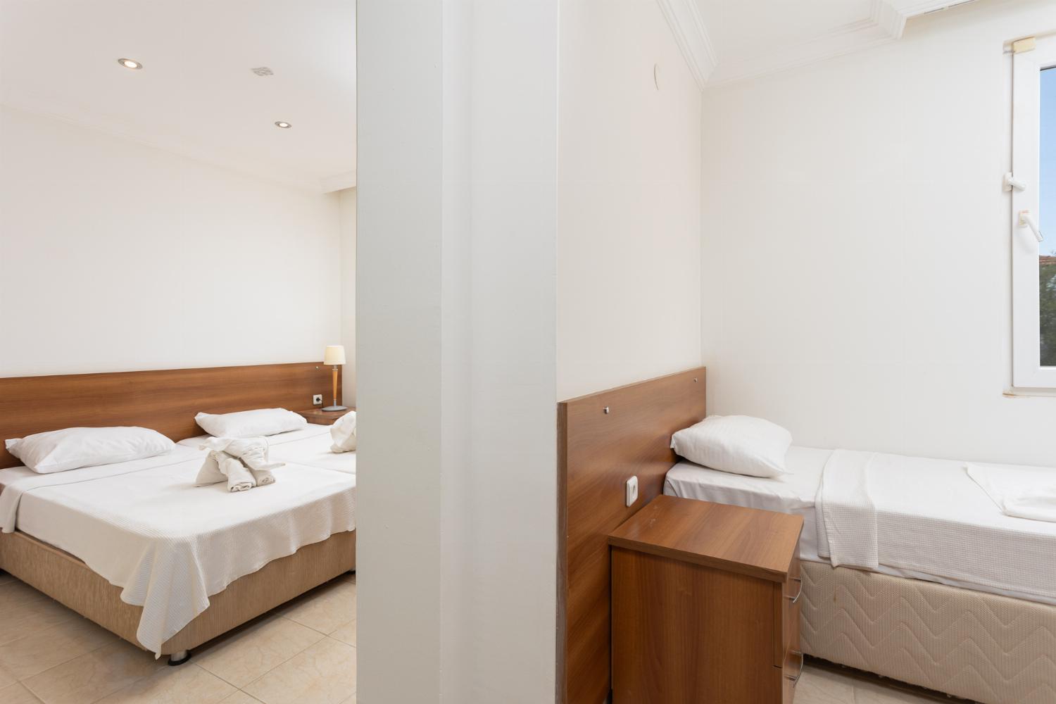Bedroom with twin beds and single bed, en suite bathroom, and A/C