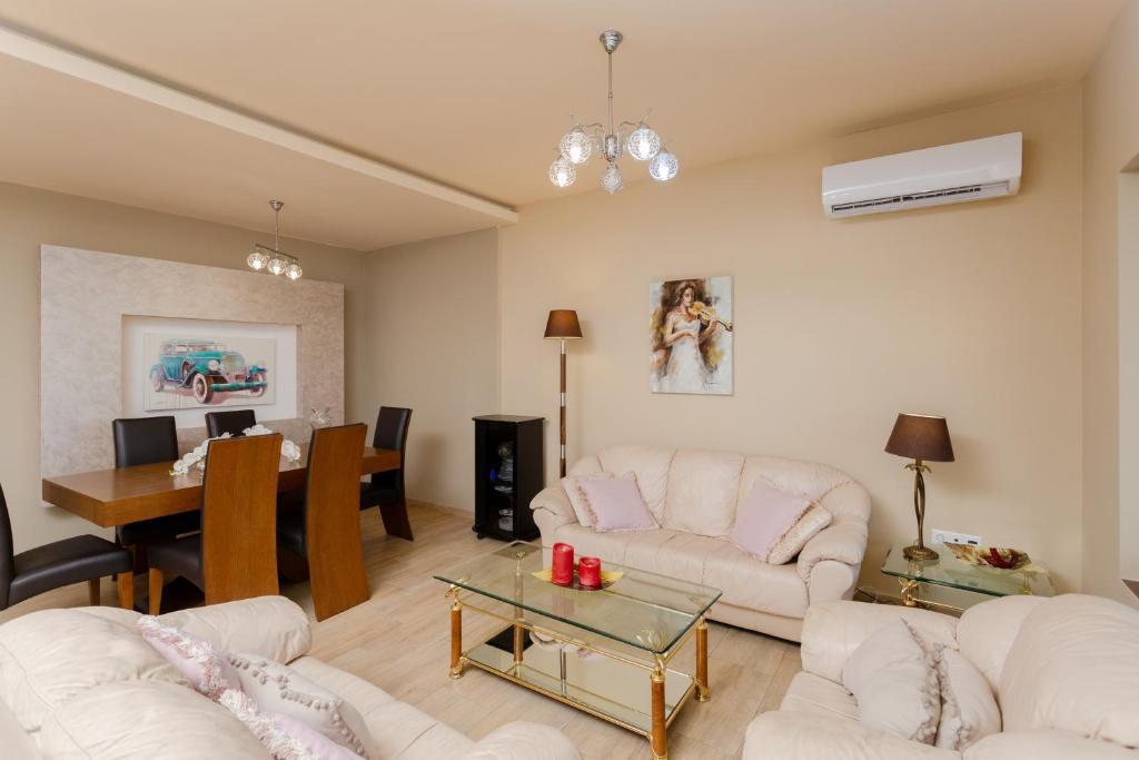 Open-plan living room with comfortable sofas, TV, WiFi, dining area with terrace access
