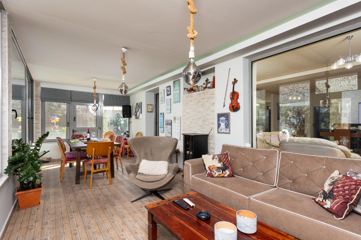 Sun room with sofa, dining area, ornamental fireplace, A/C, WiFi internet, and satellite TV