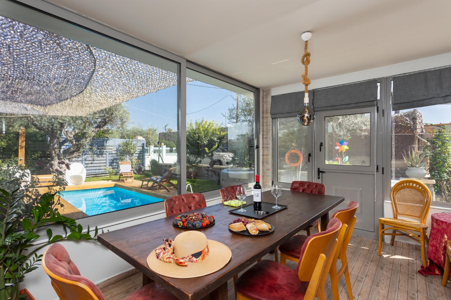 Sun room with sofa, dining area, ornamental fireplace, A/C, WiFi internet, and satellite TV