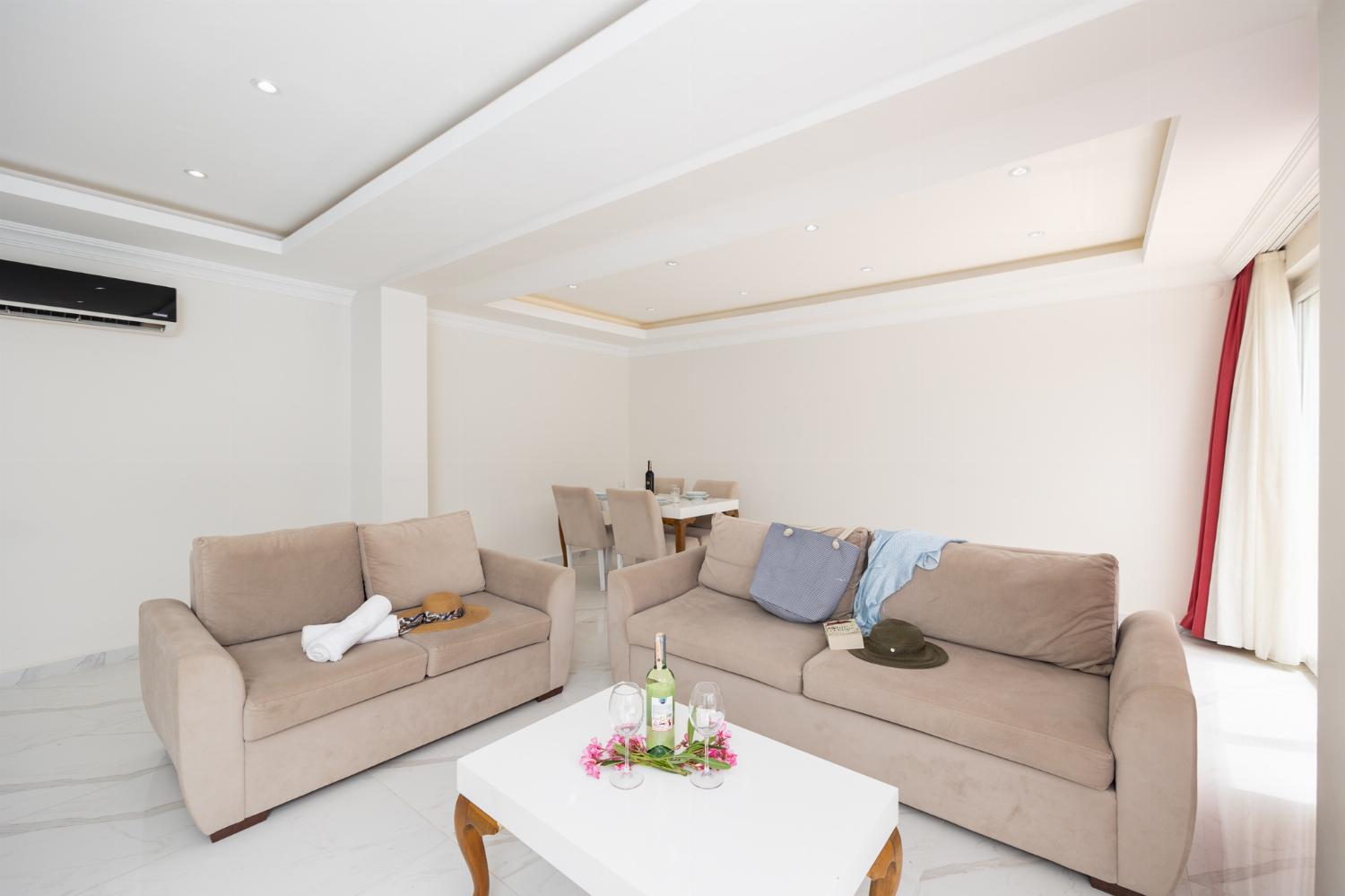 Living room with sofas, dining area, A/C, WiFi internet, and satellite TV