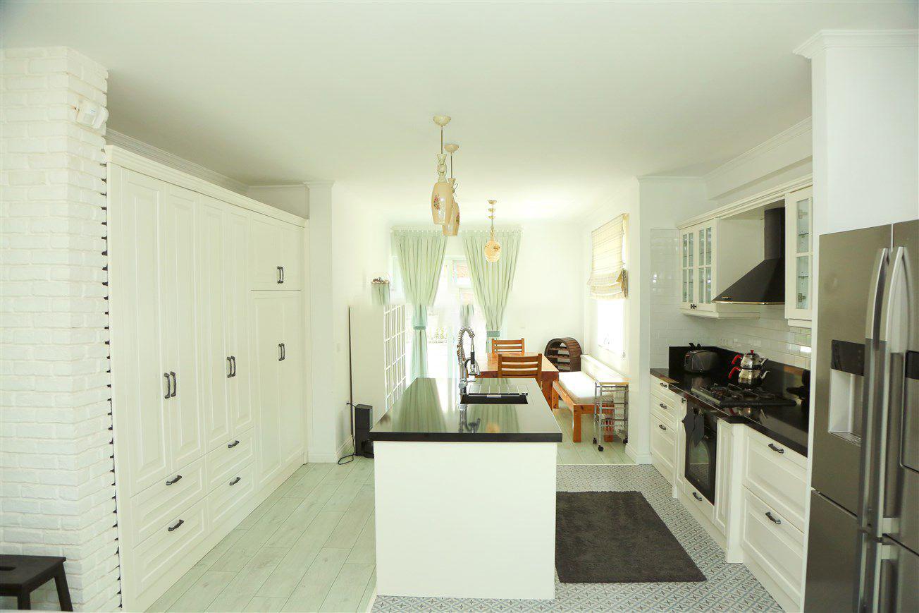 Open-plan living room with sofas, dining areas and kitchen