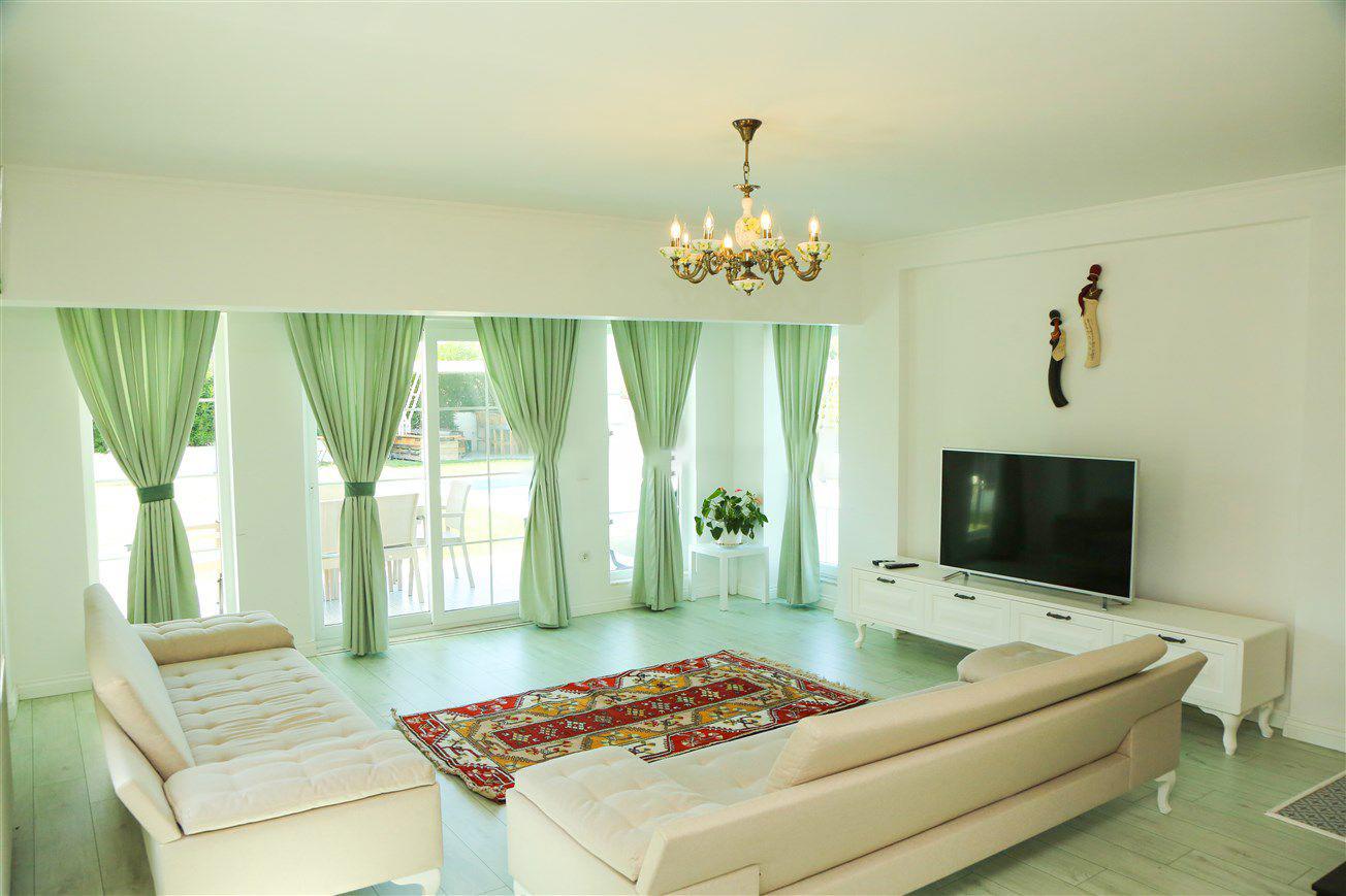 Open-plan living room with sofas, dining areas and kitchen