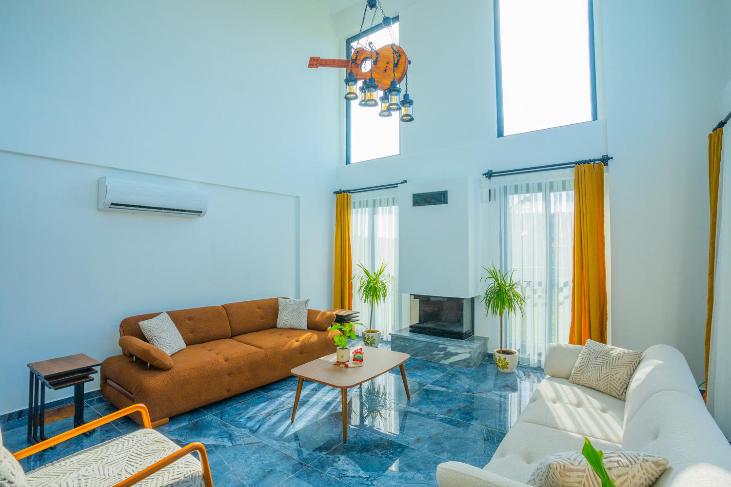 Open-plan living room with sofas, dining areas and kitchen