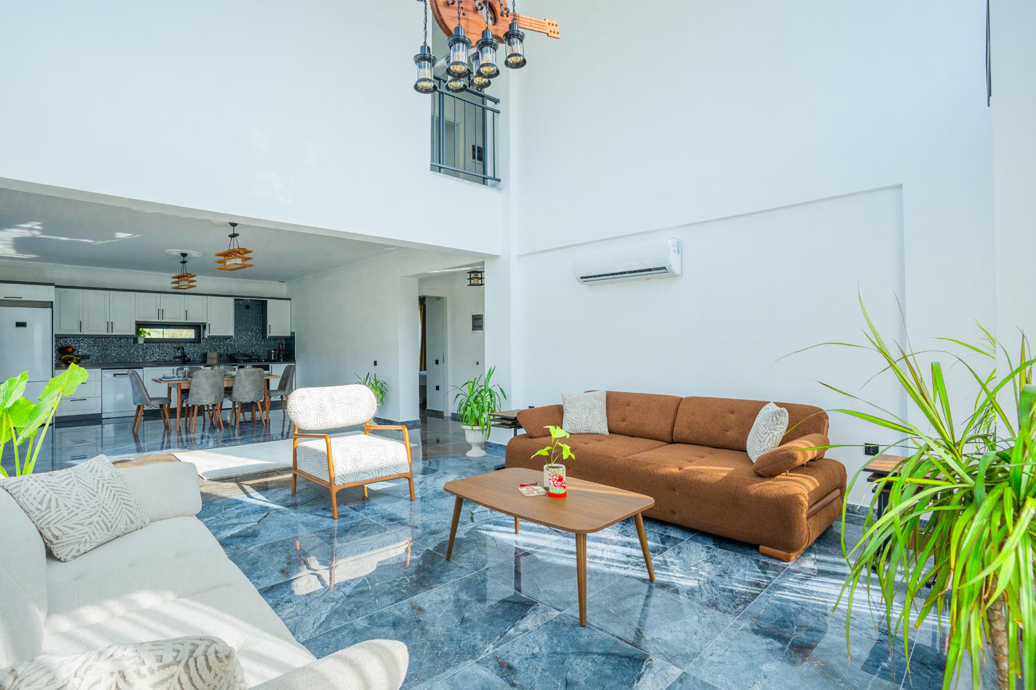 Open-plan living room with sofas, dining areas and kitchen