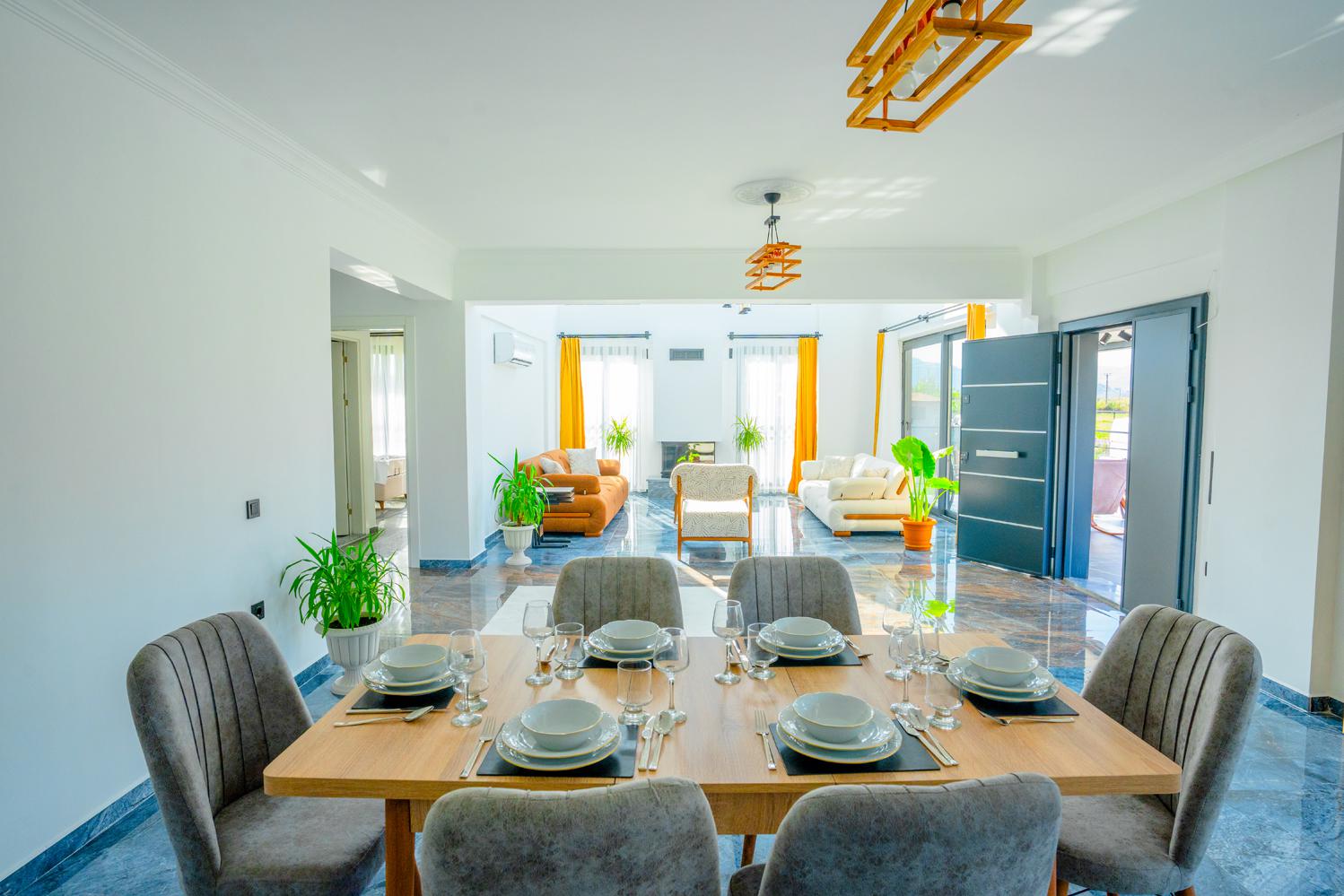 Open-plan living room with sofas, dining areas and kitchen