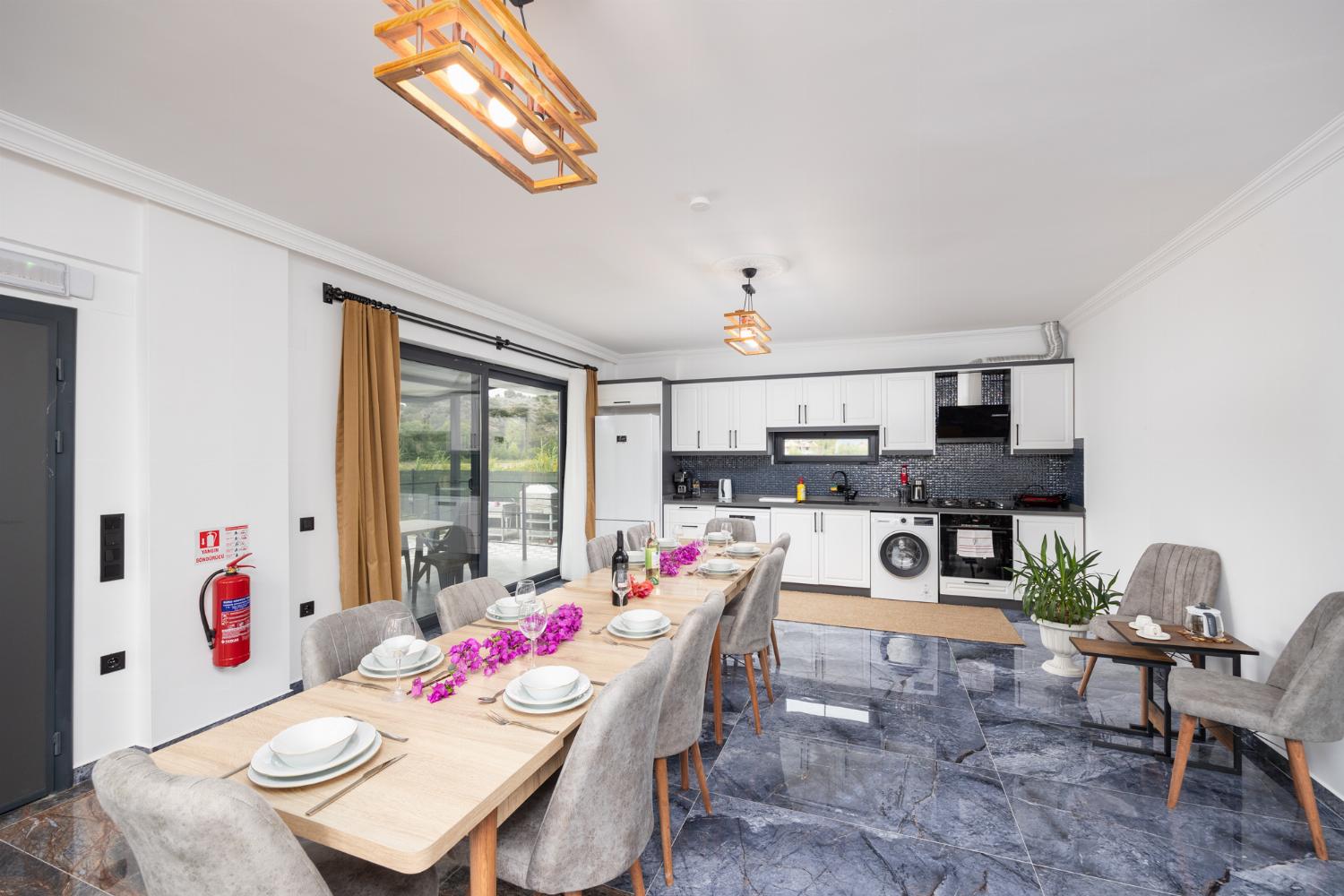 Open-plan living room with sofas, dining area, kitchen, ornamental fireplace, A/C, WiFi internet, and satellite TV