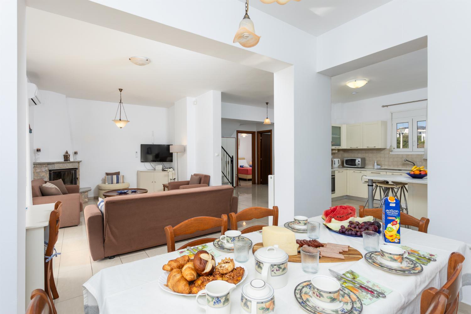 Open-plan living room with sofas, dining area, kitchen, ornamental fireplace, A/C, WiFi internet, and satellite TV