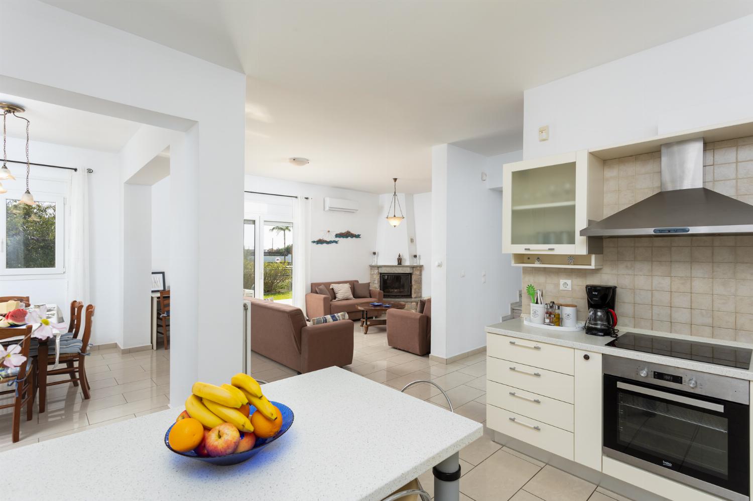 Open-plan living room with dining area, kitchen, sofas, ornamental fireplace, A/C, WiFi internet, and satellite TV