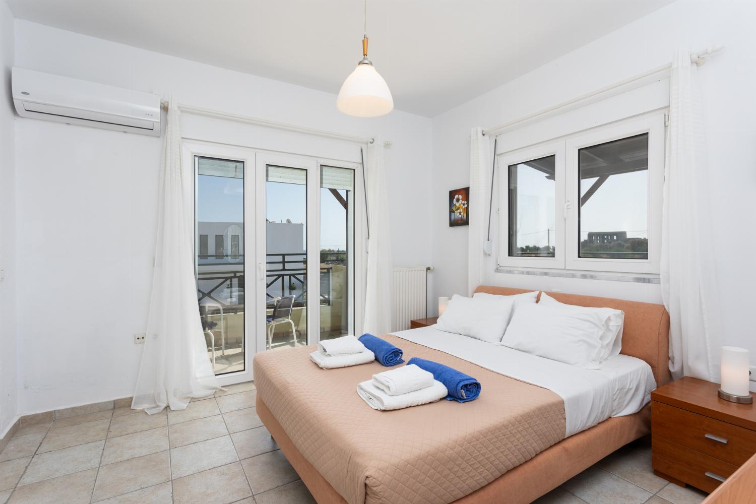 Double bedroom with en suite bathroom, A/C, and balcony access