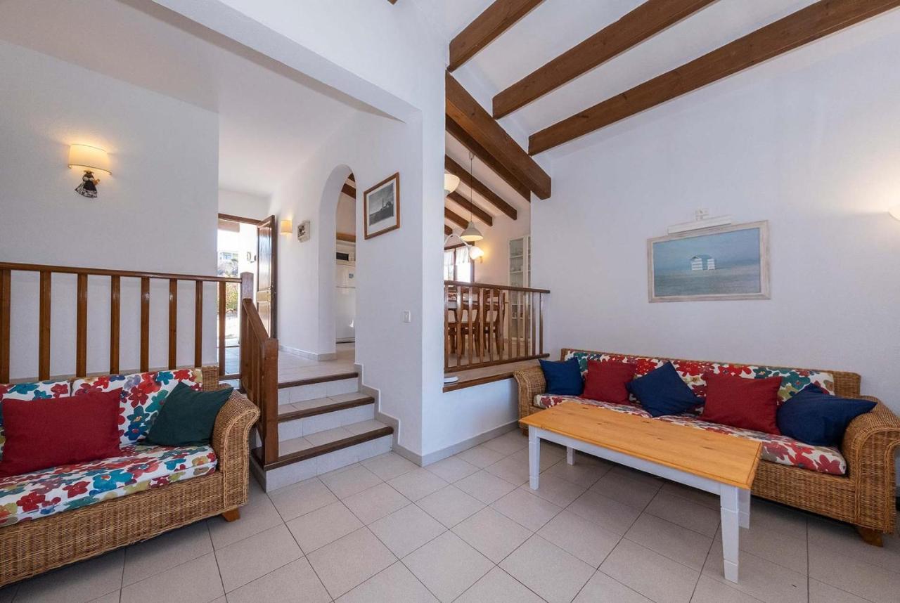 Open-plan living room with sofas, ornamental fireplace, dining area, kitchen, A/C, WiFi internet, satellite TV, DVD player, and pool terrace access