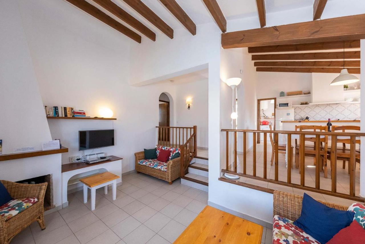 Open-plan living room with sofas, ornamental fireplace, dining area, kitchen, A/C, WiFi internet, satellite TV, DVD player, and pool terrace access