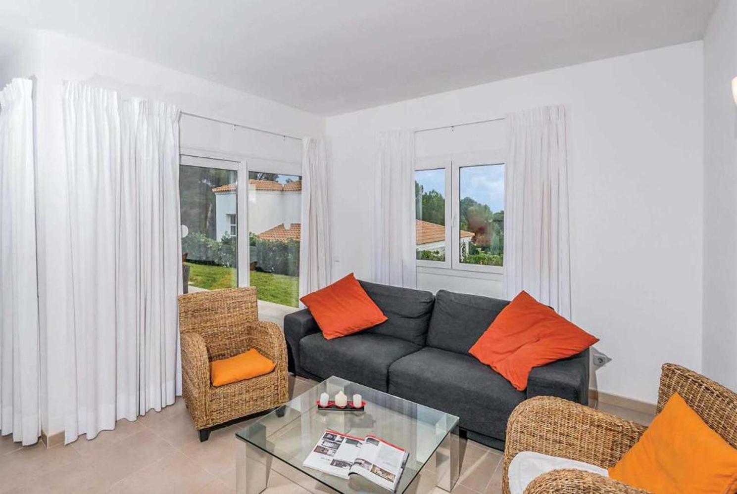 Open plan living room with A/C, TV, WiFi, comfortable sofas, patio doors