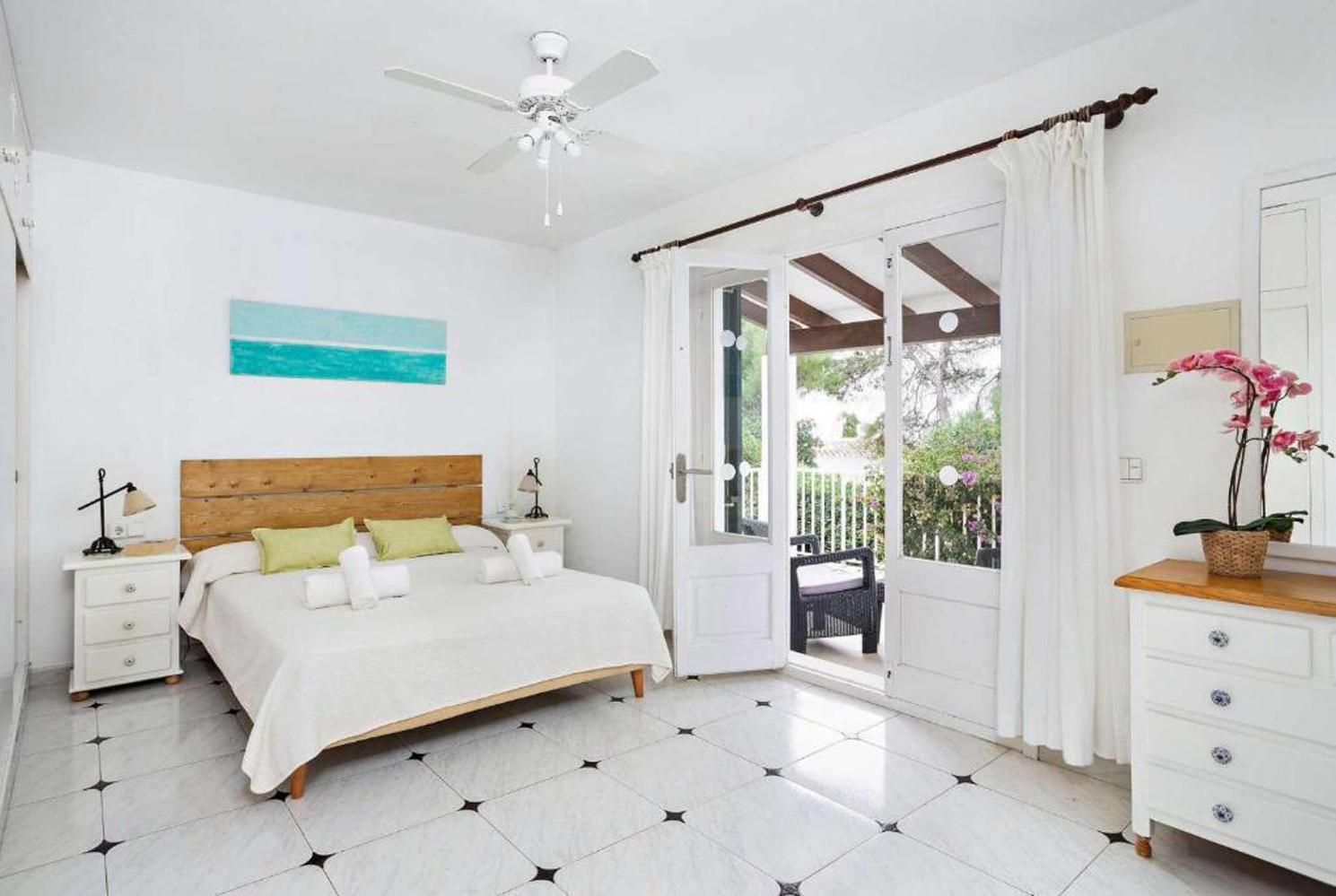Double bedroom with a fan and terrace access