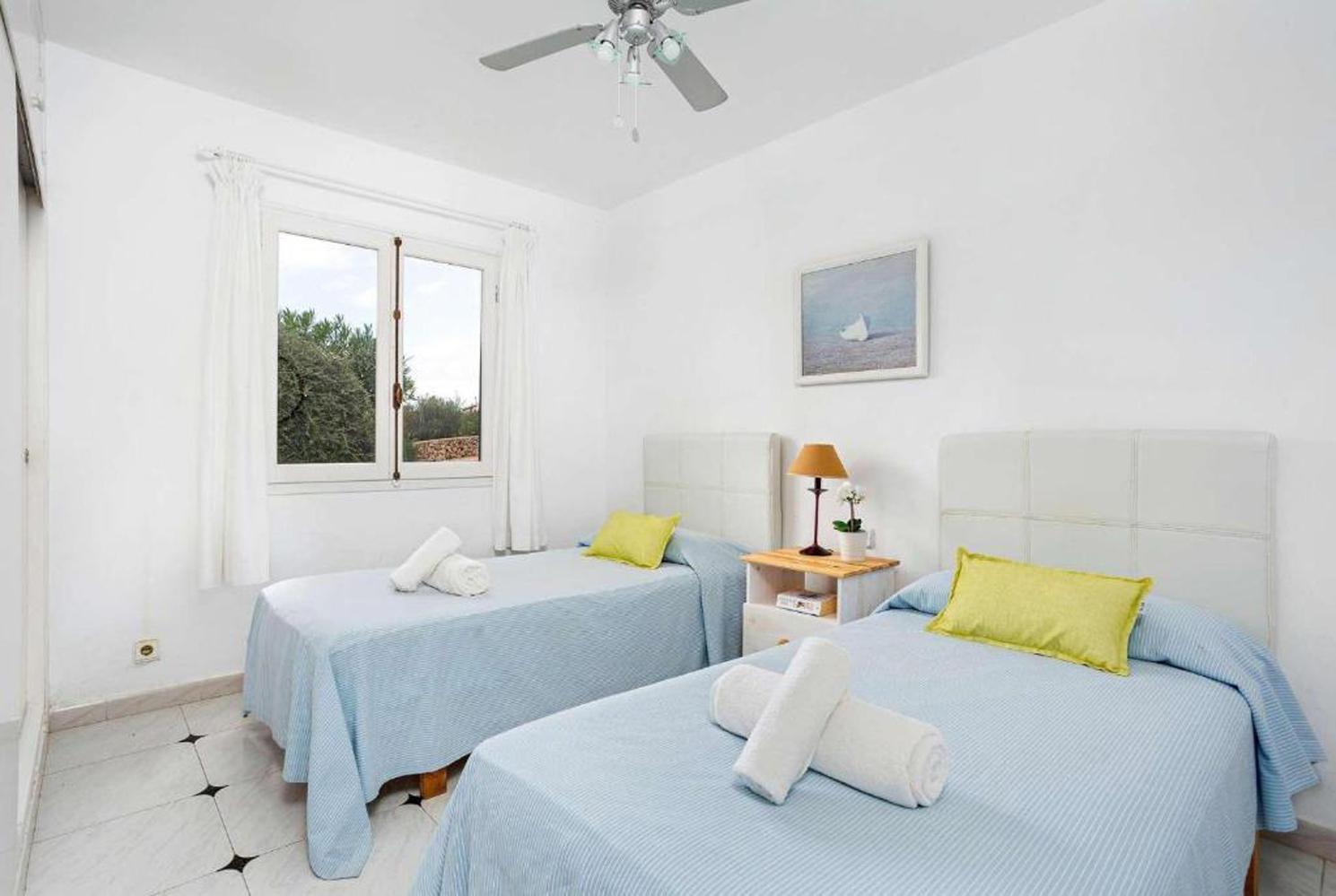 Twin bedroom with a fan