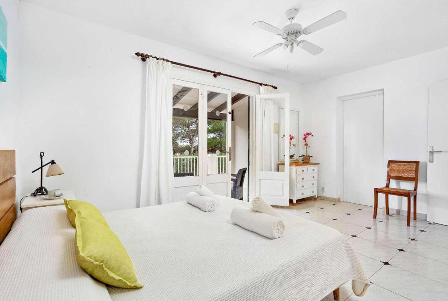 Double bedroom with a fan and terrace access