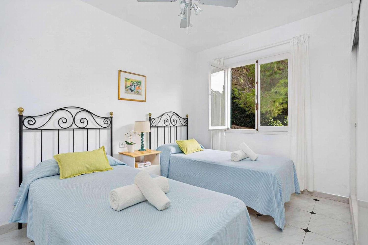 Twin  bedroom with a fan